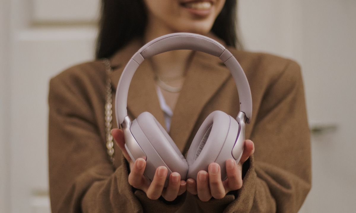 Frau hält hochwertige Over-Ear-Kopfhörer in den Händen – ideal für Tests zu Haltbarkeit und Akkulaufzeit.
