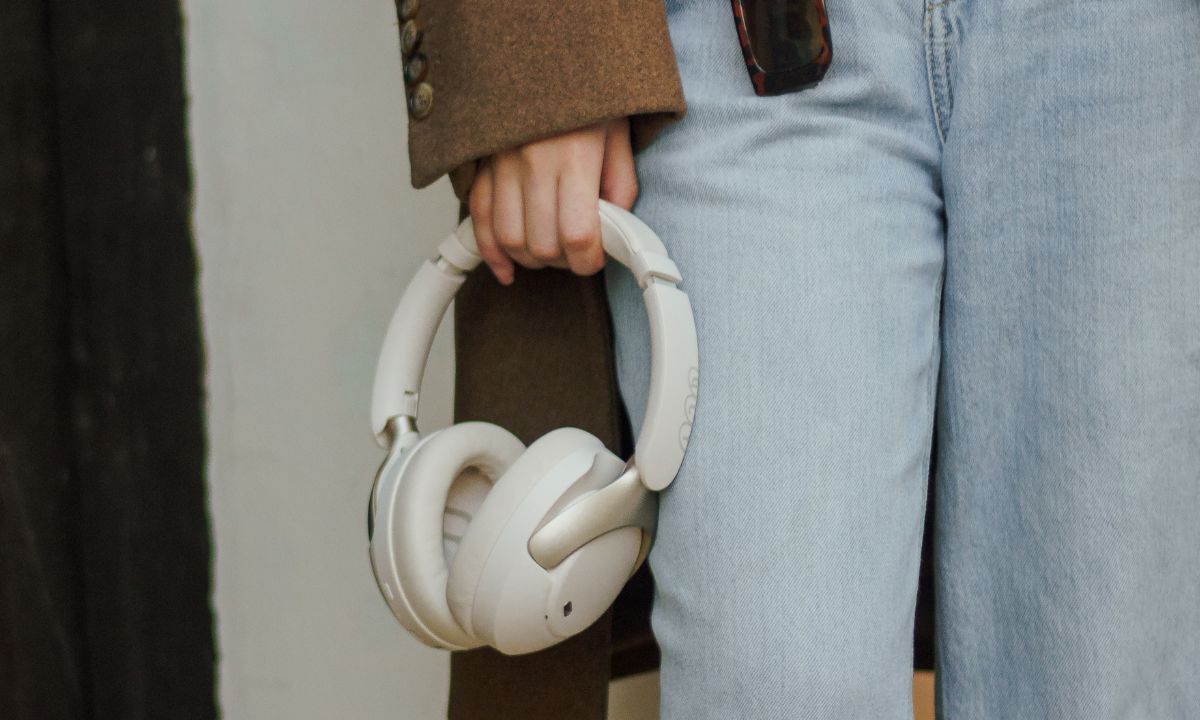 Person hält weiße Over-Ear-Kopfhörer – Frage: Sind größere Treiber besser für den Klang?