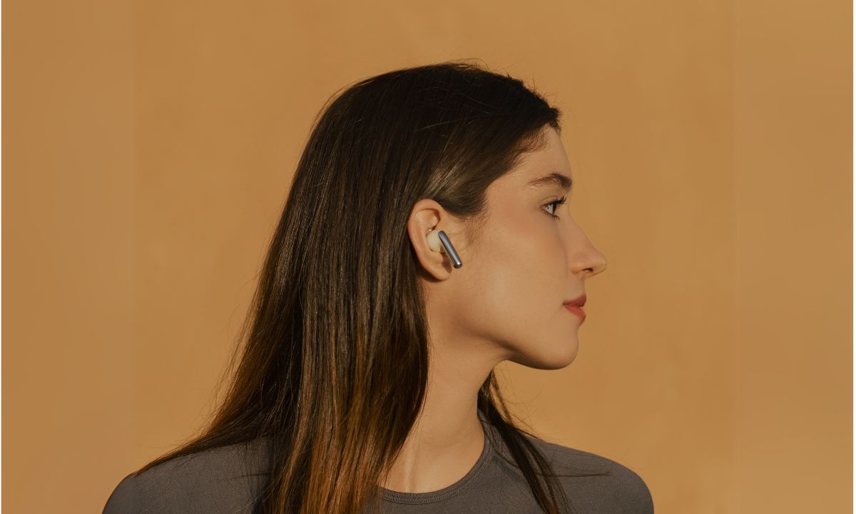 Frau mit kabellosem Ohrhörer im Profil – sicherer, intelligenter Hörgenuss ohne Gesundheitsrisiken.
