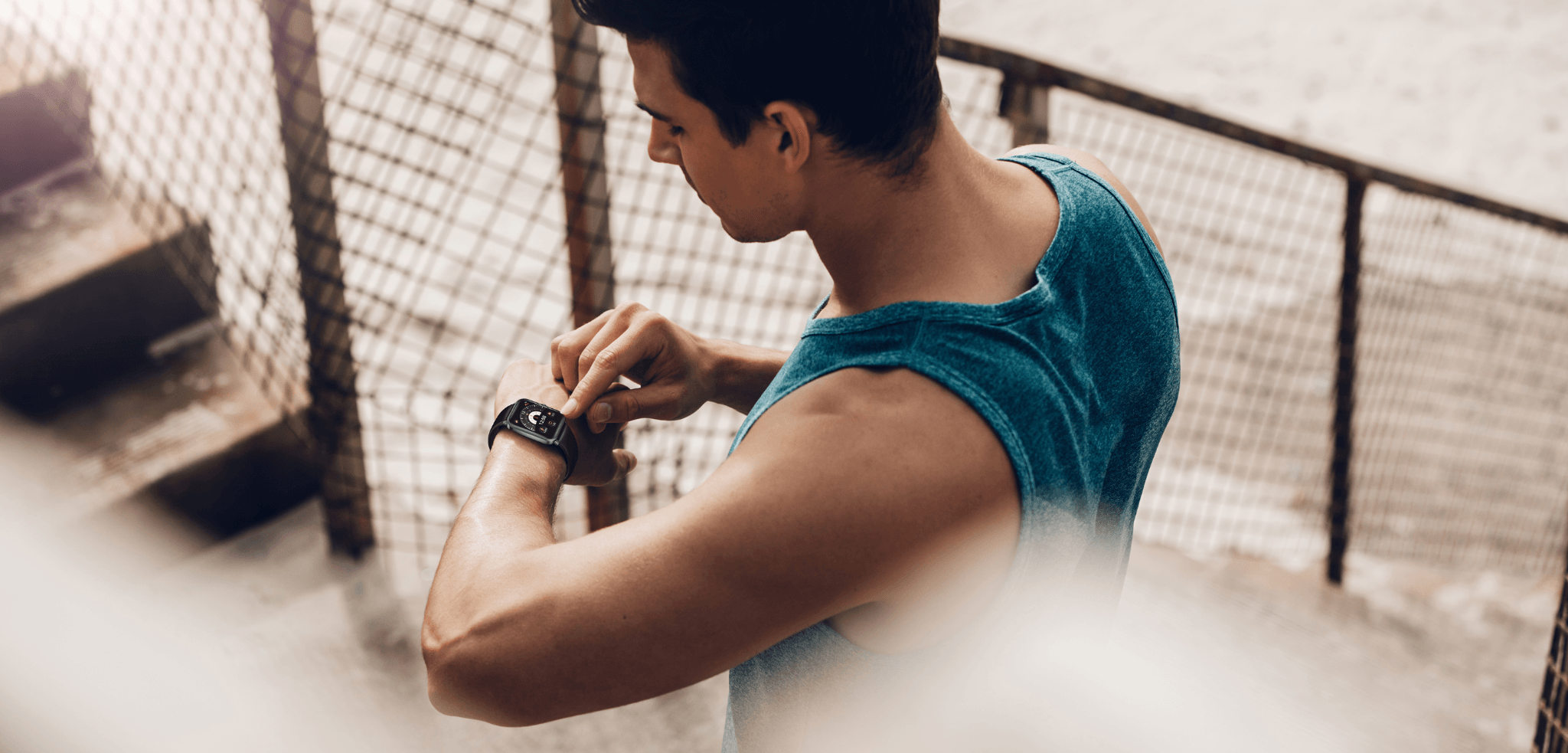 Mann checkt Smartwatch nach Workout – Fitness-Tracker für Gesundheit & Training im urbanen Setting.