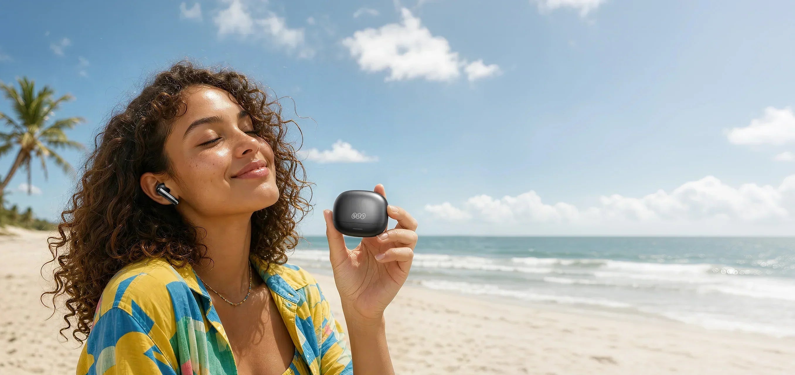 Frau am Strand mit QCY Ohrhörern im Low-Latency-Modus für verzögerungsfreien Sound beim Sport oder Gaming.
