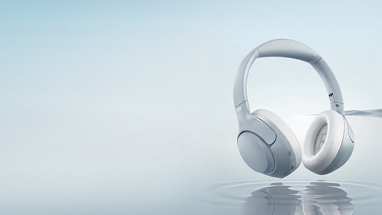 Auscultadores over-ear brancos com design moderno, flutuando sobre a água, superfície refletora, fundo minimalista