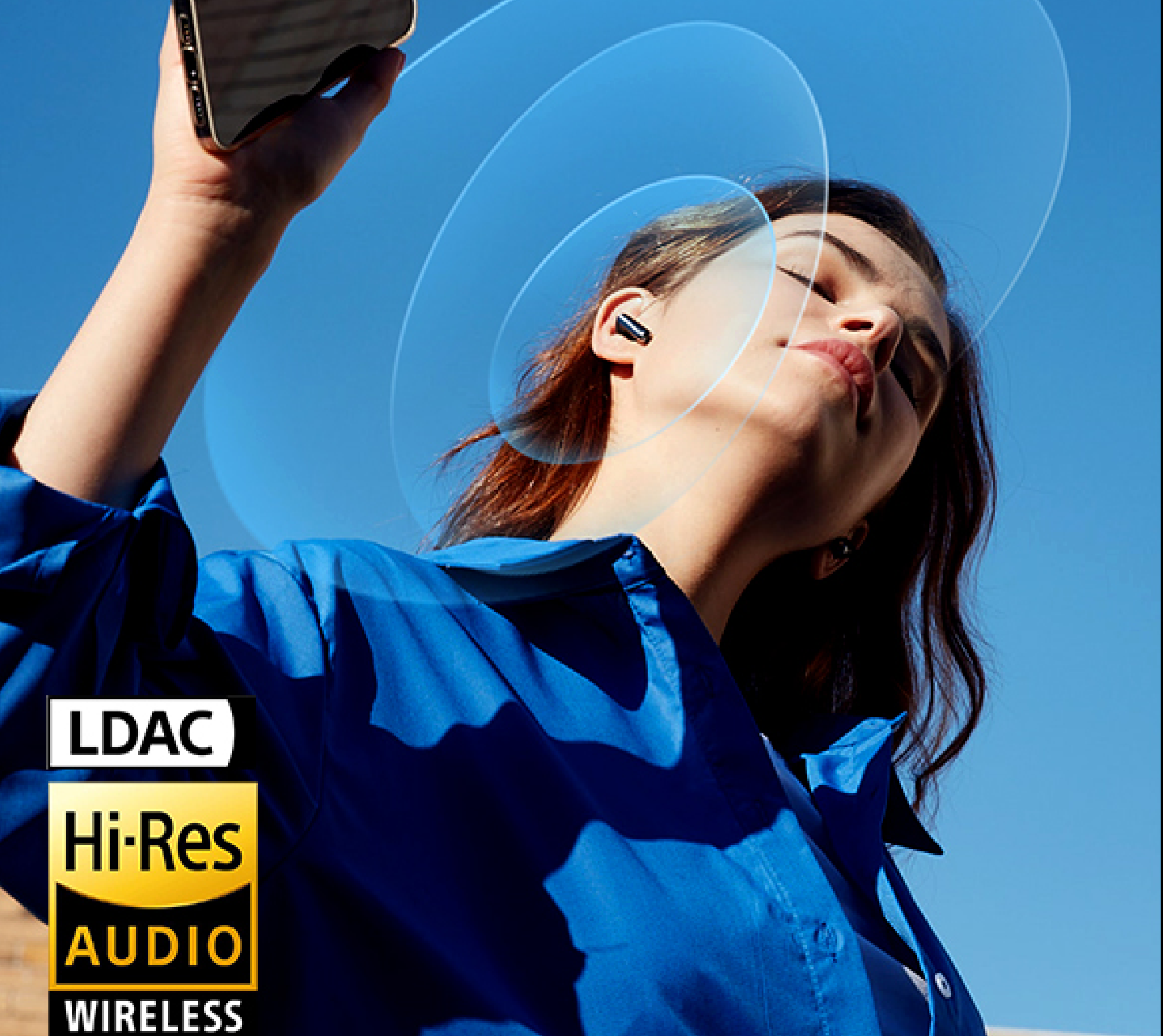 Mulher com auscultadores Hi-Res Audio sem fios sob um céu azul, a desfrutar de música através da tecnologia sem fios LDAC.