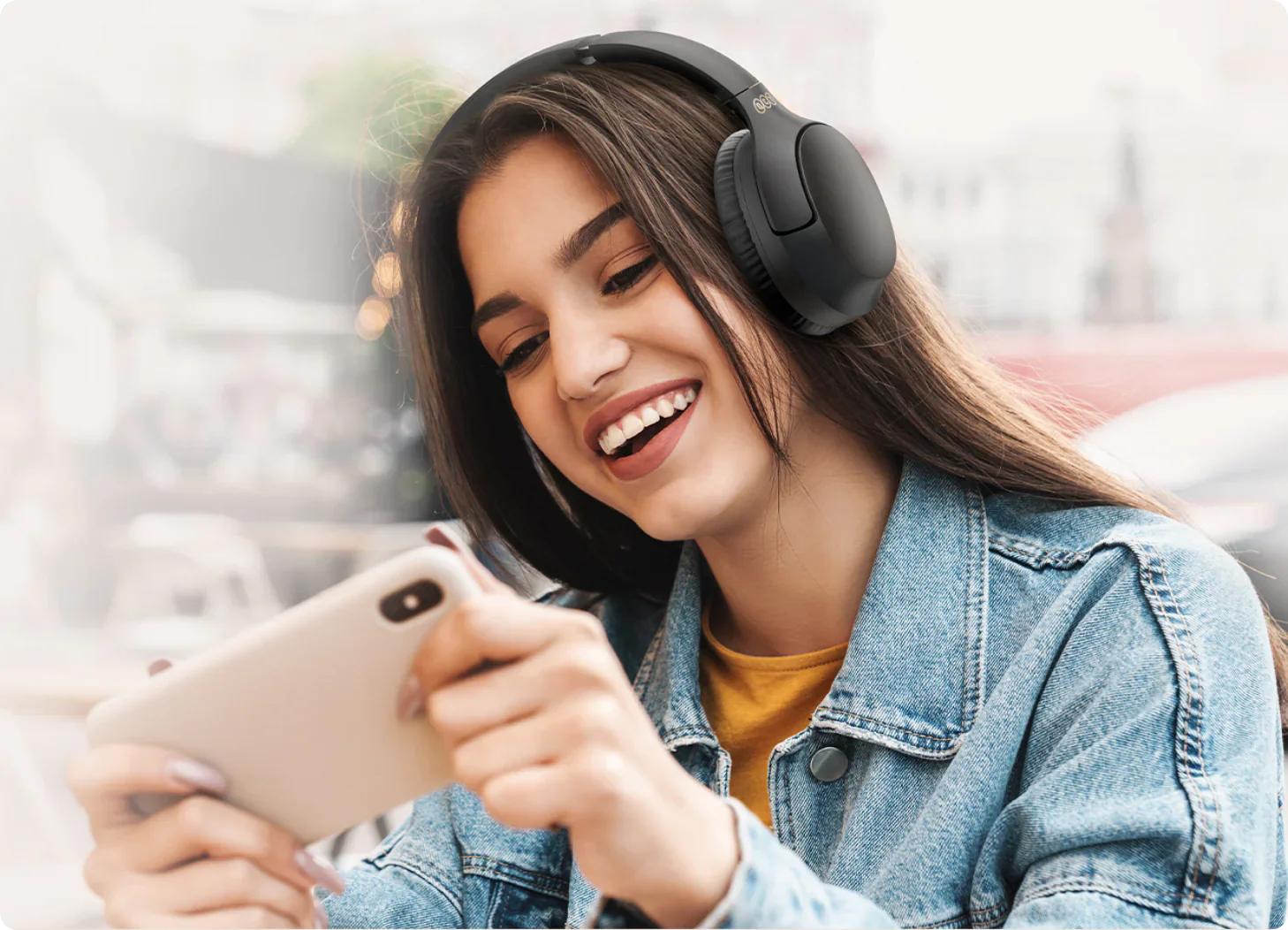 Mulher sorridente com auscultadores sem fios e smartphone.