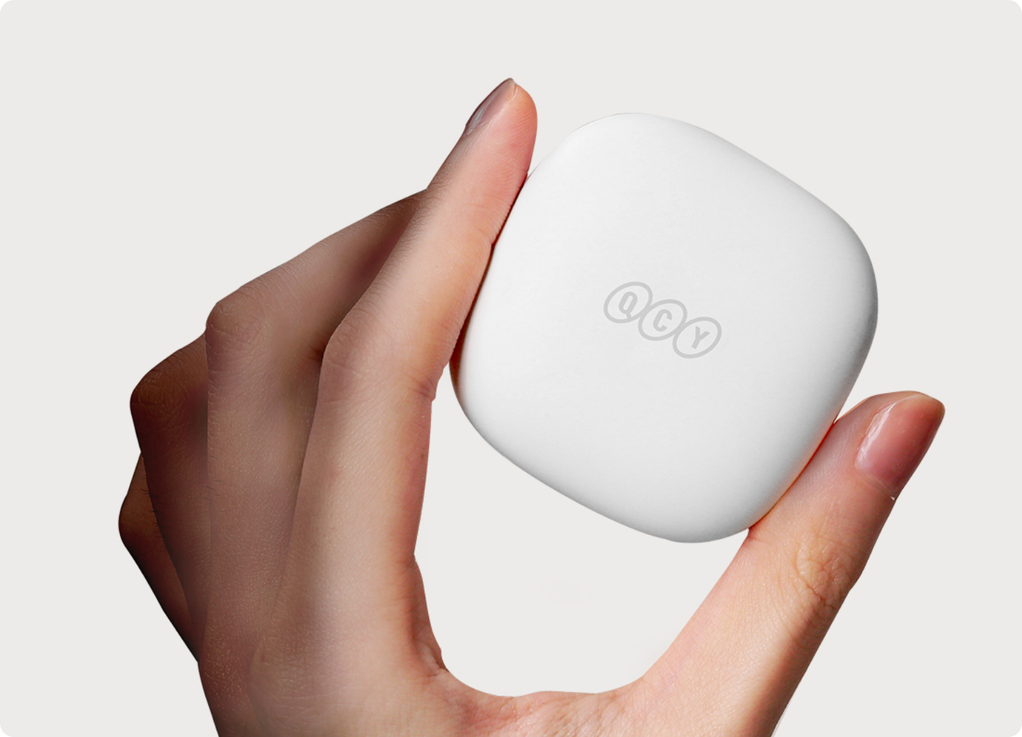 Caixa branca de auscultadores QCY na mão, design minimalista com logótipo, ideal para auscultadores sem fios.