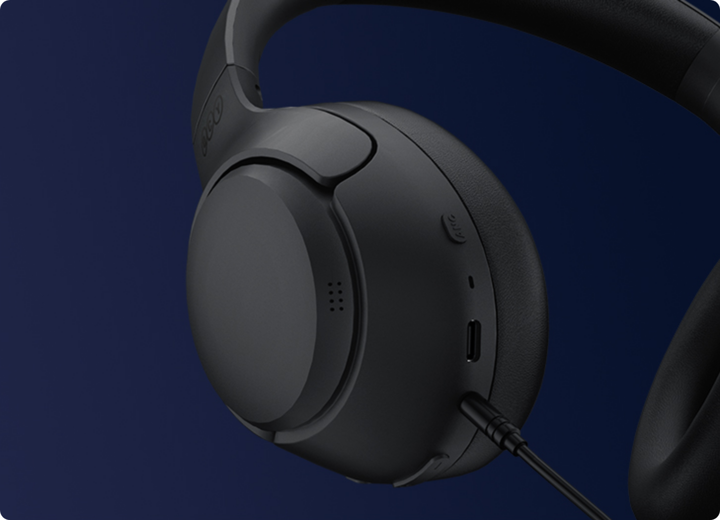 Auscultadores over-ear pretos com ligação por cabo e microfone.