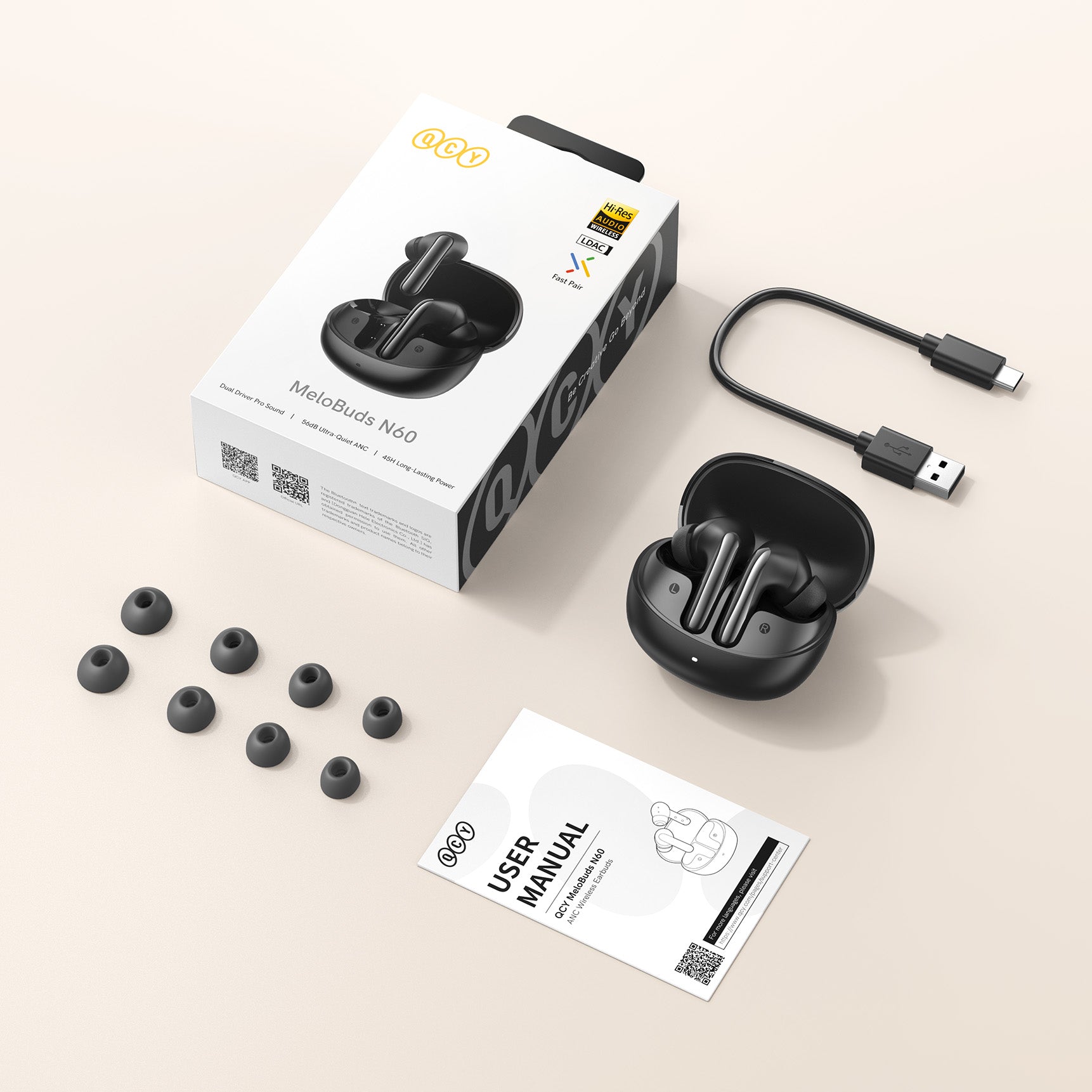 Auriculares sem fios QCY MeloBuds N60 com estojo de carregamento, cabo USB, pontas de substituição e manual de instruções sobre fundo claro